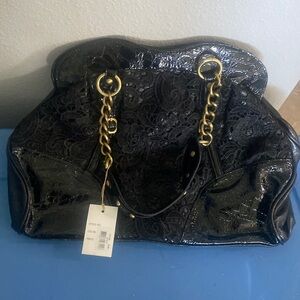 Black purse large. Has lace on the front and has chains on the handles.